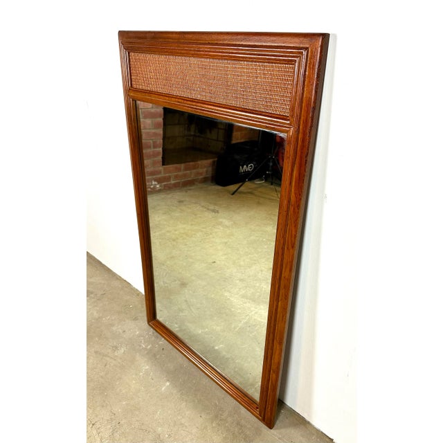 A high-quality Drexel campaign-style Passage Collection wall mirror including textured cane top panel. The piece displays...