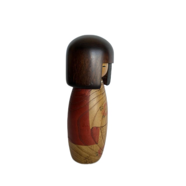 Most Sosaku or creative Kokeshi dolls are decorated with colorful kimono. This pretty doll's natural wood grains are the...