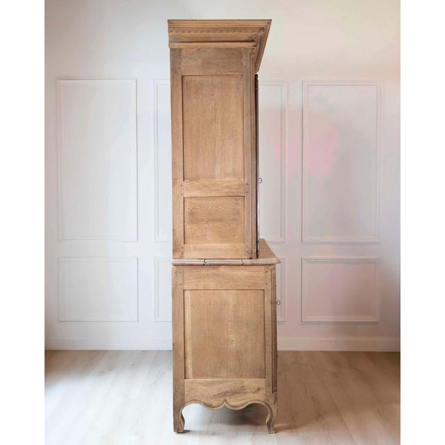 An early nineteenth-century French Norman buffet deux corps in natural solid oak. The two-part form presents four paneled...