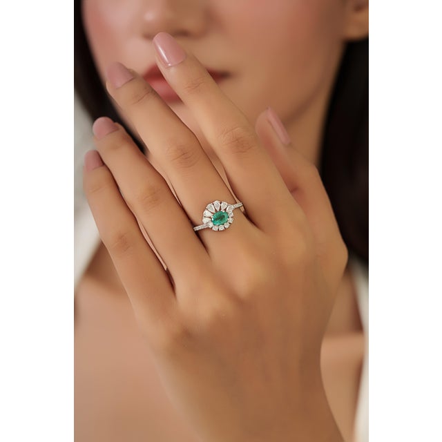 This sunburst Ring features a 0.68 carat oval-shaped emerald set in 18K white gold. The emerald measuring 4.5 x 6 mm,...