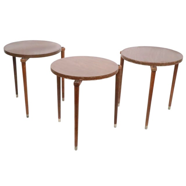 Set of three stacking side, drink, occasional tables, having faux wood formica tops, with tapering pole wood legs. The...