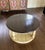 A beautifully designed round coffee table featuring a striking two-tone finish in white and wire-brushed tobacco. The...