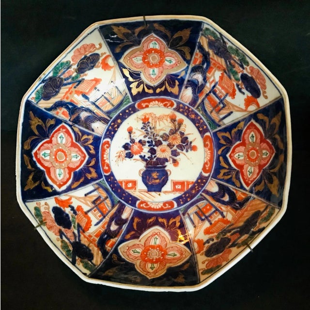 This large, distinctive, octagonal porcelain Imari bowl is painted in rich, inky blue, copper, orange, red and green. It's...