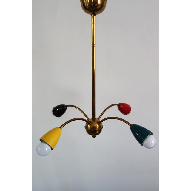 Spider or Sputnik chandelier dating from the 1960s. Brass frame and four painted metal reflectors. Very slight signs of...