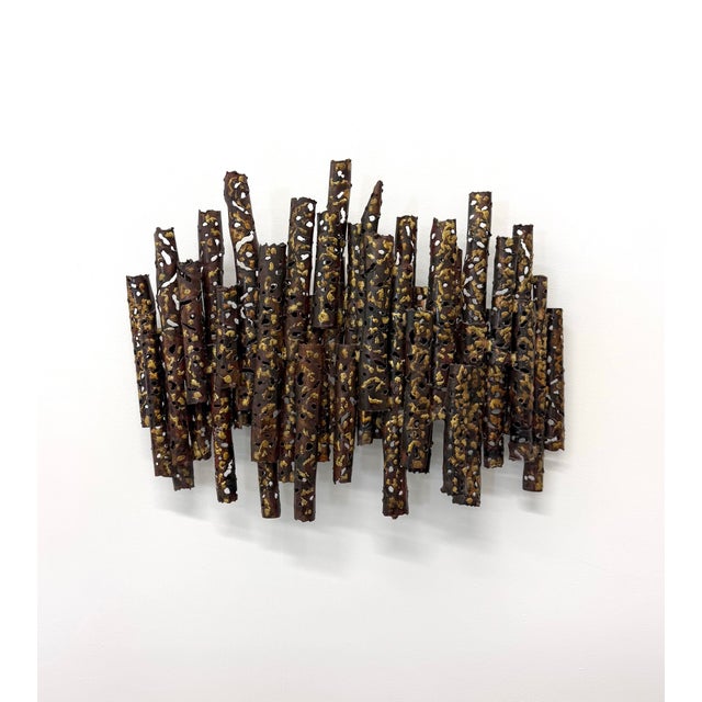 A sculptural vintage wall hanging composed of densely layered, torch-cut metal tubes arranged in an irregular vertical...
