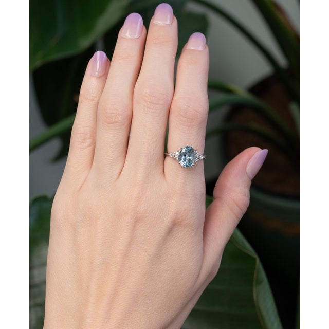A serene 2.3ct aquamarine in an elegant oval cut glows with soft ocean-blue brilliance. Accented with natural diamonds and...