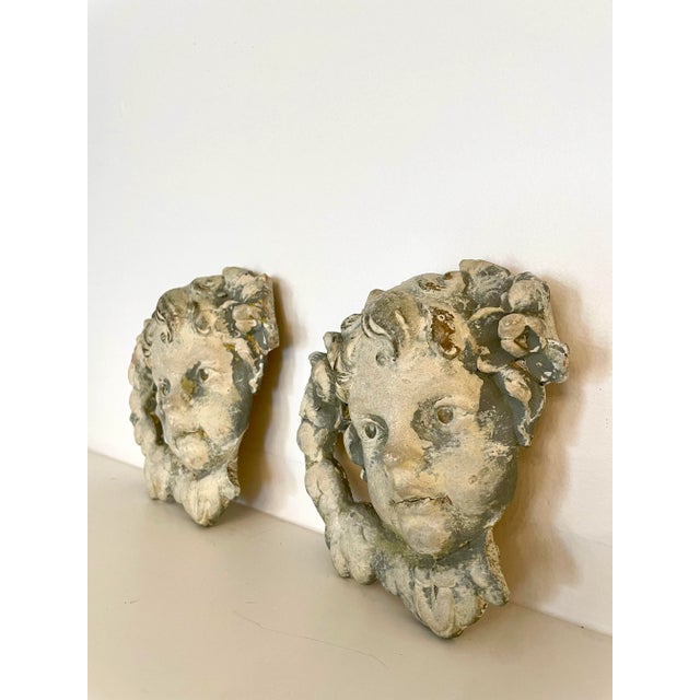 This angelic pair of formed cherub faces reflect the putti style of the late Renaissance period. Made of plaster or chalk...