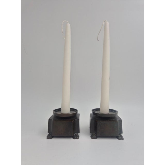 A pair of bronze candle holder in solid bronze with decor of lion paws. Designed by Jacob Ängman (1876-1942) for GAB /...