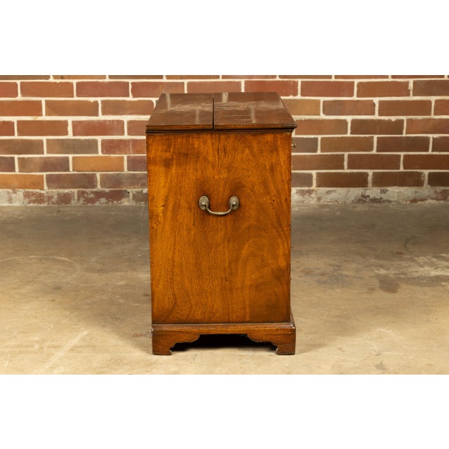 An English walnut Campaign butler's desk from the 19th century with writing area, three drawers, bracket feet and brass...