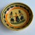 Antique bowl with hand painted design featuring a traditional Breton woman with floral/botanical accents.. Marked "Henriot...