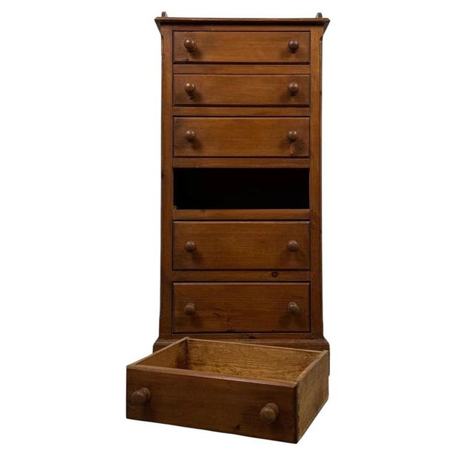 A charming and highly practical vintage 20th-century narrow chest of drawers, well constructed in pine and distinguished...