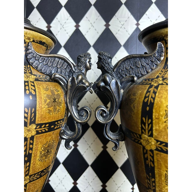 Pair of grand 32" vintage Neoclassical-style figural table lamps with sculptural metal urn-form bodies. Each lamp is...