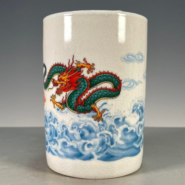 A striking Chinese porcelain brush pot (bitong) featuring a creamy, all-over crackle glaze. The cylindrical vessel is...