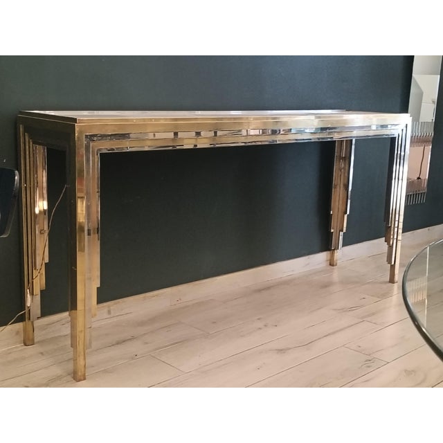 A beautiful and rare console table with a brass and chrome-plated metal frame; the glass top is backlit. The console table...