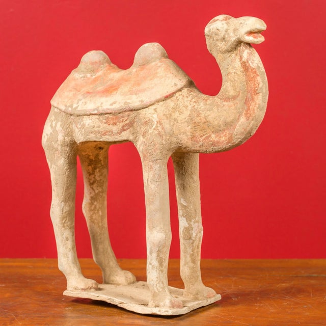 A Chinese Han Dynasty period mingqi terracotta camel circa 202 BC-200 AD, with traces of original polychromy. Created in...