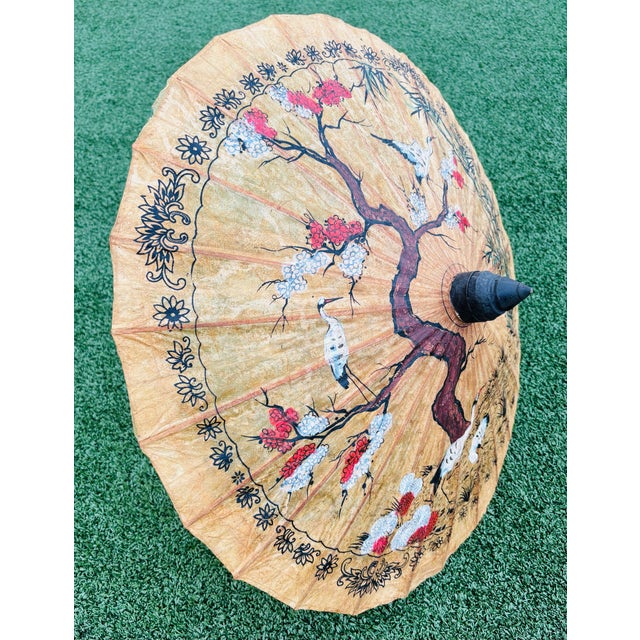 A vintage accent circa 1950s Asian Rice Paper Parasol Umbrella. Hand painted with cranes in a large fruitful tree. Be sure...