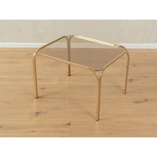 Classic side table from the 1970s. High-quality metal frame in gold with a glass table top. Quality features: very good...