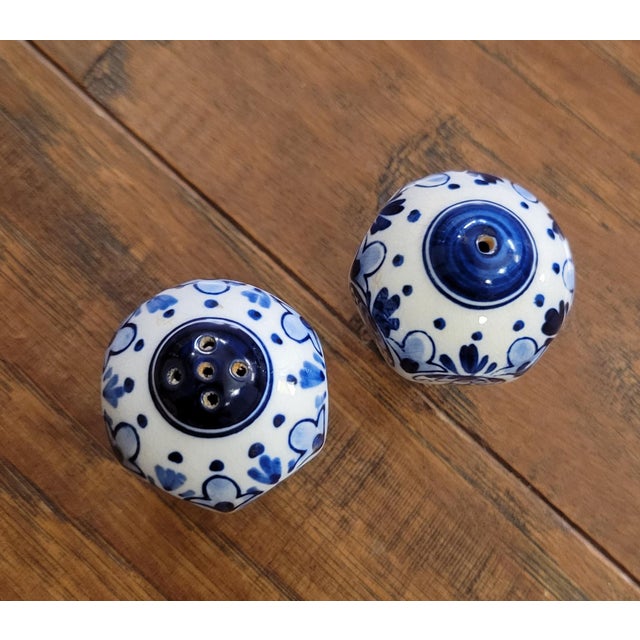 Hand painted under glaze in the Delft blue style, but unmarked. Stoppers at the bottom. Hexagonal sides. 3/8" tall. 1 1/2"...