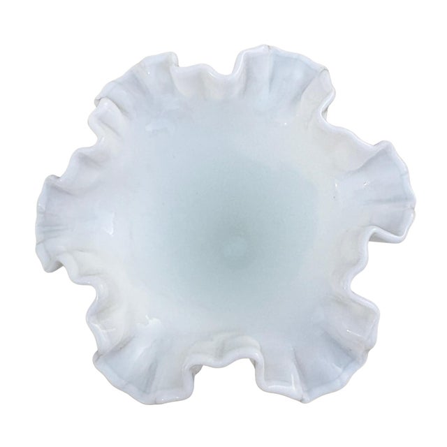 Made by Fenton, this vintage milk glass trumpet vase has a hobnail texture and a fluted, ruffled rim. It stands at 8.5”...
