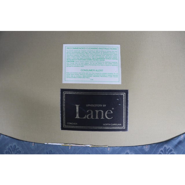 A pair of light blue upholstered wingback chairs with carved shell mahogany legs, by Lane Furniture.