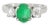 Elegant 14K white gold three-stone ring featuring a natural oval emerald flanked by two brilliant round diamonds. The...