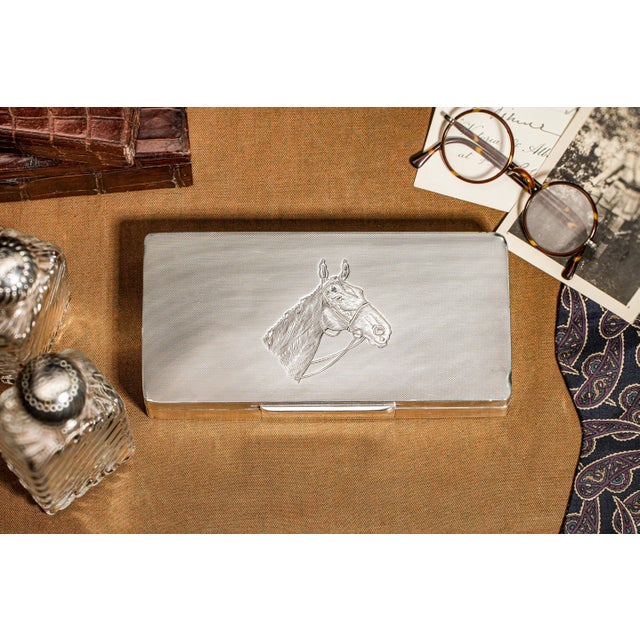 This stunning sterling silver box is a testament to exquisite craftsmanship, featuring an intricate engine-turned design...
