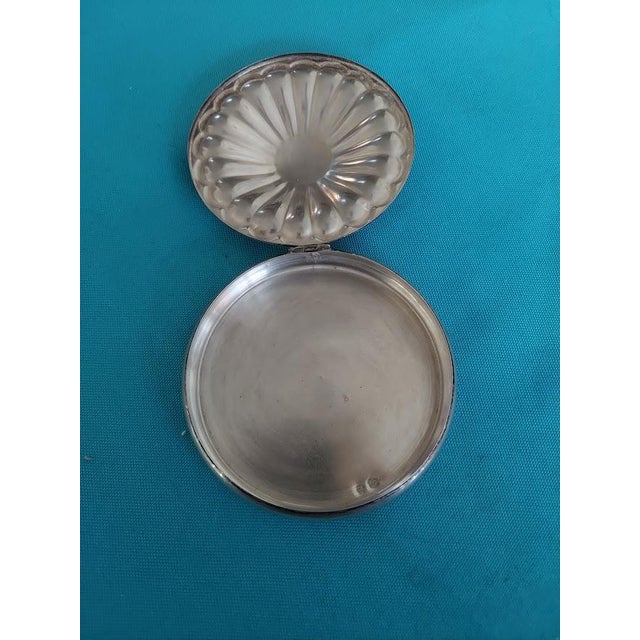 An elegant vintage silver trinket box featuring a circular form, decorative fluted design, and hinged lid. Measuring...