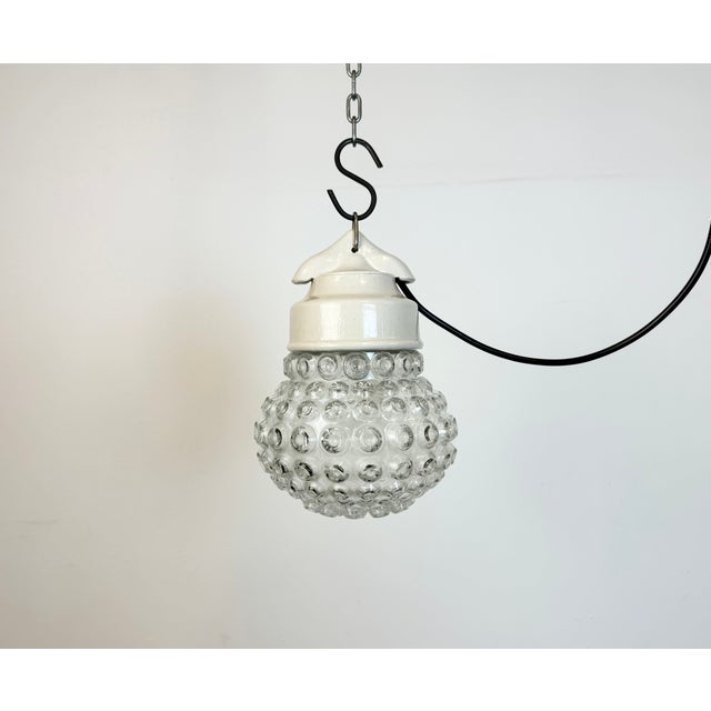 Vintage industrial light made in former Czechoslovakia during the 1970s. It features a white porcelain top and a glass...