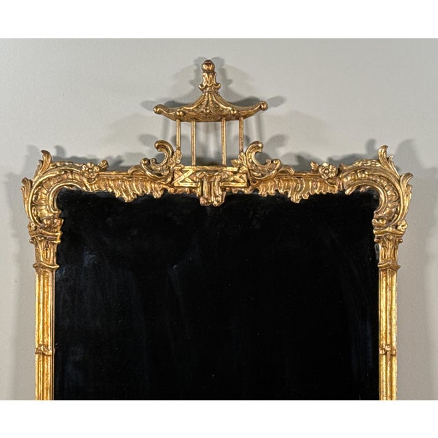 This vintage early 20th century Chinese Chippendale / Chinoiserie wall mirror features a carved giltwood frame with...