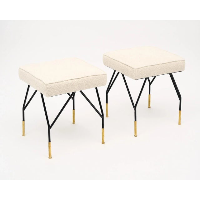Pair of Italian stools with black lacquered steel and brass legs. New upholstery is done in a white wool blend. This pair...