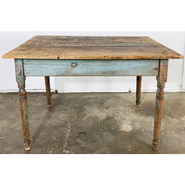 Antique primitive farmhouse table featuring weathered paint to base. Two tones of blue to aprons. Wonderful patina. Leg...