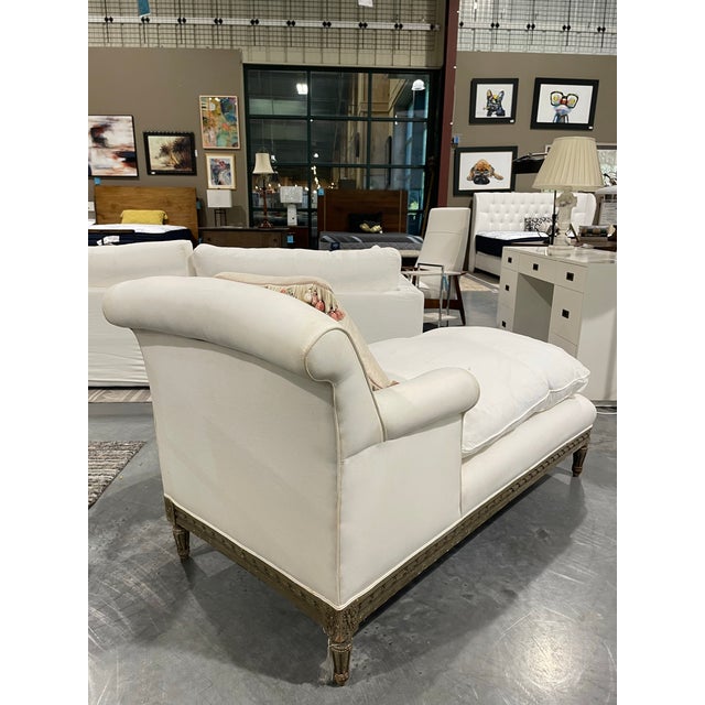 This antique 19th Century French style chaise features a carved wood frame with fluted legs and ribbon trim. The wood is...