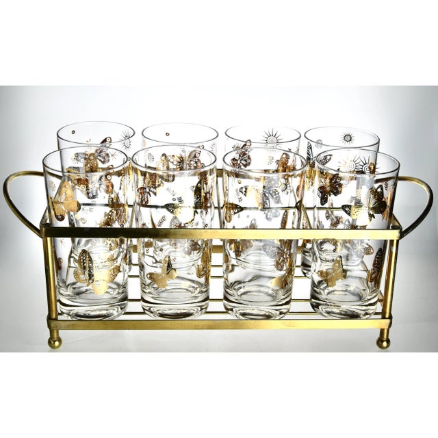 A glamorously stylish Hollywood Regency set of 8 highballs, embellished with high karat gilded butterflies, sun, stars and...