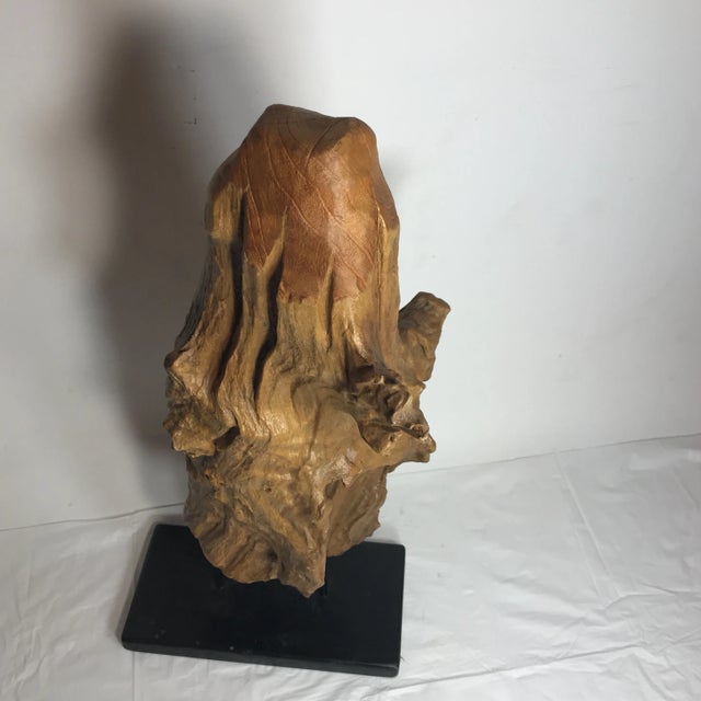 A driftwood decoration on a iron and wood black stand .