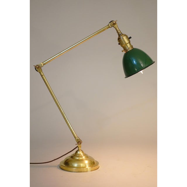A brilliant and exceptional Industrial Machine Age Brass double arm articulating table lamp designed and manufactured by...