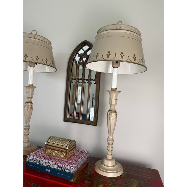 A charming pair of vintage tole lamps featuring hand‑painted floral motifs and elegant gold detailing. These lamps offer a...