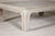 A teak wood Ming style whitewash coffee table from the 20th century with chow legs and weathered patina. This vintage teak...