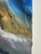 A dynamic watercolor painting of a dramatic cliff in a mountain range, set against a cobalt sky, with a building, some...