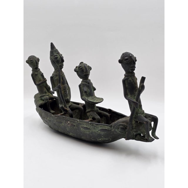 The product is a 16" Benin Bronze Boat Sculpture from Nigeria, showcasing the rich African tribal culture through its...