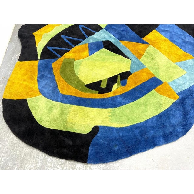A Mid Century Modern floral abstract tapestry attributed to Edward Fields. The colorful design includes tones of blue,...