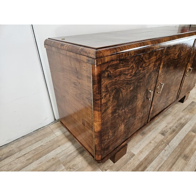 An elegant Art Deco sideboard dating back to the 1940s, crafted from walnut and featuring an extraordinary decorative...