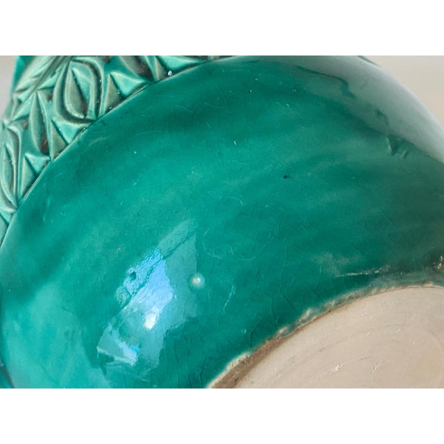 It is a hand painted ceramic pitcher in green color. It was made in the 1960s in England. It represents a bird with...