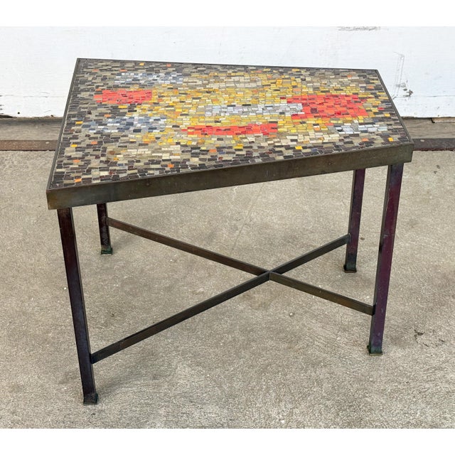 This trapezoid side table has a hand-set glass tile mosaic top in an abstract composition of red, orange, saffron, and...