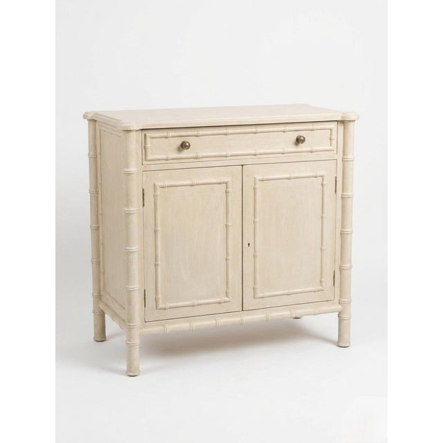 This elegant vintage cabinet features the iconic Hollywood Regency aesthetic, characterized by its sophisticated faux...