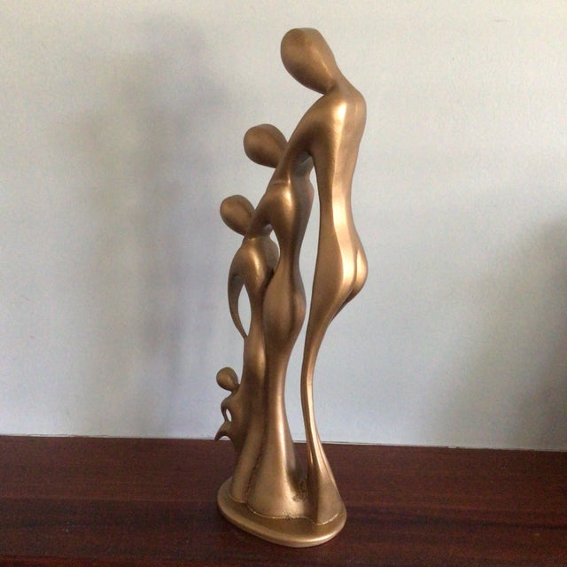 This abstract JART. Resin sculpture depicts a man, a woman, and two children embracing with the oldest child raising up...