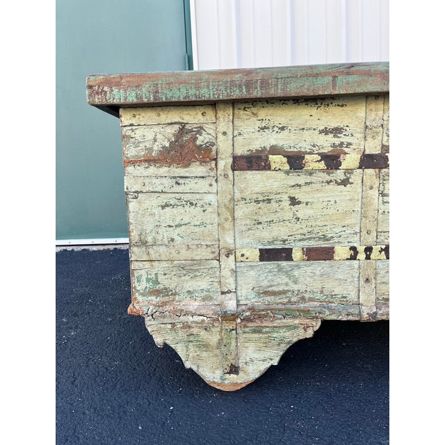 Circa late 1800s. Very large antique trunk on wooden wheels. Painted with pastel colorings in an eye-catching patchwork...