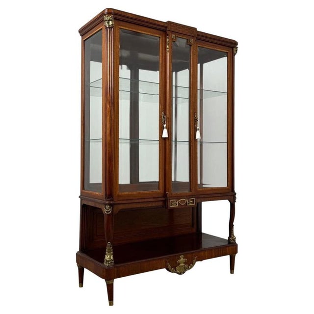An exceptionally elegant 19th-century French display cabinet, finely crafted from mahogany and distinguished by its...