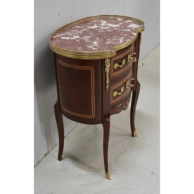 Chiffonnière Kidney veneer of mahogany, top with Red Marble Pyrenees surrounded by a brass openwork gallery. It opens with...