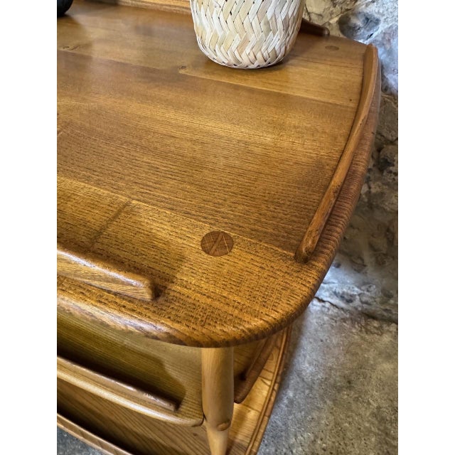 Absolutely stunning example of a mid-century drinks cart manufactured by Ercol. The trolly is crafted from solid elm with...