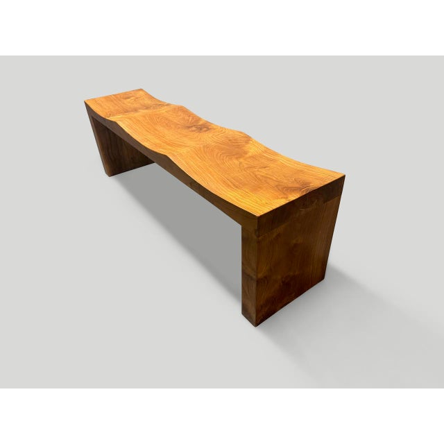 Minimalist teak wave bench. A solid single slab of ancient teak wood is hand carved into a wave style. Both usable and...
